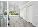 Bright, open-concept living room with wood flooring, trey ceiling, and sliding glass doors to the pool area at 8818 Poe Dr, Hudson, FL 34667