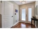 Foyer with hardwood floors, double door entry, coat closet and decorative table at 1353 Curlew Rd, Dunedin, FL 34698