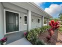 Inviting front entrance with a dark-green door, lush landscaping, and a welcoming porch at 1453 Otten St, Clearwater, FL 33755
