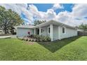 Side view of a home with a modern exterior, manicured lawn, and fresh landscaping at 1453 Otten St, Clearwater, FL 33755