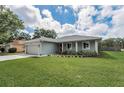 Attractive one-story home featuring a well-maintained lawn, a garage, and landscaping at 1453 Otten St, Clearwater, FL 33755