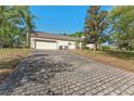 Spacious three car garage showing brick paved driveway at 1591 Chestnut W Ct, Palm Harbor, FL 34683