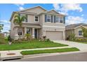 Charming two-story home with a well-maintained lawn, neutral paint, a two-car garage, and decorative blue shutters at 17923 Cantarina Cv, Bradenton, FL 34211