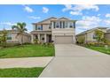 Charming two-story home with a well-maintained lawn, neutral paint, a two-car garage, and decorative blue shutters at 17923 Cantarina Cv, Bradenton, FL 34211