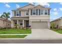 Charming two-story home with a well-maintained lawn, neutral paint, a two-car garage, and decorative blue shutters at 17923 Cantarina Cv, Bradenton, FL 34211