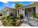 Inviting front entrance with decorative wreath and lush greenery around the well-lit front door at 2029 Winding Oaks Dr, Palm Harbor, FL 34683