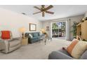 Comfortable living room with ceiling fan and sliding glass doors to the pool area at 2029 Winding Oaks Dr, Palm Harbor, FL 34683