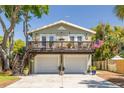 Inviting home featuring a spacious 2 car garage, an upper deck, and classic American charm at 224 Ontario Ave, Crystal Beach, FL 34681