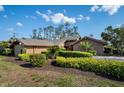 Beautiful single-story home with well-maintained landscaping and a red front door at 29844 Baywood Ln, Wesley Chapel, FL 33543