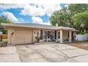 A cozy single-story home offers a convenient attached garage, tidy landscaping, and a charming covered porch at 333 Acropolis Dr, Dunedin, FL 34698