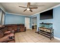 Comfortable living room boasts tile floors, a ceiling fan, and a large sectional sofa for relaxation at 333 Acropolis Dr, Dunedin, FL 34698