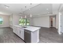 An open-concept kitchen island featuring white cabinets, stainless steel appliances, and a seamless flow to the living area at 3926 Southern Valley Loop, Brooksville, FL 34601