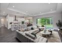A luxurious living room showcasing an open floor plan, a modern kitchen, and large windows with backyard views at 3926 Southern Valley Loop, Brooksville, FL 34601