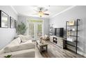 Bright living room features a modern ceiling fan, luxury vinyl plank flooring, and a sliding glass door to the outside at 4221 W Spruce St # 1229, Tampa, FL 33607