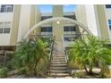 Condominium entrance featuring stairs flanked by tropical plants with an arch overhead at 4681 1St Ne St # 306, St Petersburg, FL 33703