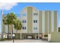 Exterior of Racquet Club Northeast Condominiums featuring covered parking and mature tropical trees at 4681 1St Ne St # 306, St Petersburg, FL 33703