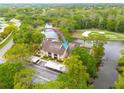 Scenic aerial view of condo near water, with lush trees, golf course, and parking area at 50 St Andrews Pl # 50, Oldsmar, FL 34677