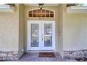 Elegant double front doors with transom window offer a warm welcome to the home at 513 Tweed Ave, Seffner, FL 33584