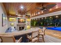 Poolside bar and fireplace with wood ceiling and tropical-themed decorations at 556 21St Ne Ave, St Petersburg, FL 33704