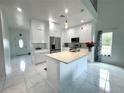 Bright, modern kitchen features white cabinets, a large center island, and stainless steel appliances at 7044 Brickell Ct, Spring Hill, FL 34609