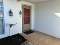 Cozy covered entrance featuring a decorative storm door, a welcome mat, and a charming exterior lantern at 7114 Parrot Dr, Port Richey, FL 34668