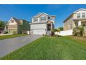 Charming two-story home featuring a manicured lawn, decorative driveway, and stone-accented entryway at 7513 S Sherrill St, Tampa, FL 33616