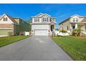 Charming two-story home featuring a manicured lawn, decorative driveway, and stone-accented entryway at 7513 S Sherrill St, Tampa, FL 33616