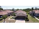 An aerial view of this cozy home boasts meticulous landscaping, a two-car garage, and a serene neighborhood setting at 832 King Leon Way, Sun City Center, FL 33573
