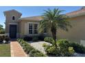 Close up of the front garden featuring tropical landscaping with pavers and stucco exterior at 832 King Leon Way, Sun City Center, FL 33573