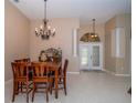 Elegant dining room featuring a chandelier, decorative columns, and tile flooring, with views of the front entrance at 8376 Golden Prairie Dr, Tampa, FL 33647