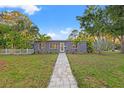 Charming single-story home features a well-maintained yard with a welcoming walkway and lush tropical landscaping at 1136 Serpentine S Dr, St Petersburg, FL 33705