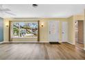 Bright living room showcasing wood-look floors, a large window, and a welcoming front door at 1250 12Th Sw Ct, Largo, FL 33770