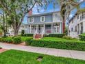 Charming two-story home featuring a welcoming front porch with swing, manicured lawn, and brick walkway at 1403 W Watrous Ave, Tampa, FL 33606