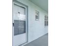 Close-up of exterior unit door with white screen door and trim; natural light shines through at 1706 Belleair Forest Dr # 336, Belleair, FL 33756