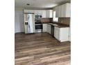 Kitchen with stainless steel appliances, white cabinets and wood-look floors at 1809 Driftwood N Cir, Oldsmar, FL 34677