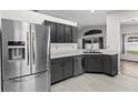 Modern kitchen with stainless steel appliances, gray cabinets, and sleek countertops at 26850 Middleground Loop, Wesley Chapel, FL 33544