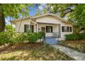 Lovely bungalow-style home with a quaint front porch, iron railings, and beautiful landscaping at 3411 N 12Th St, Tampa, FL 33605