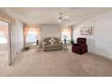 Bright living room showcasing cozy furniture, neutral carpet, ceiling fan and views to the exterior through the windows at 34150 Estates Ln, Wesley Chapel, FL 33543
