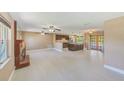 Open-concept living area with a brick fireplace, ceiling fans, and views into the kitchen at 3572 Pocahontas Dr, Largo, FL 33774