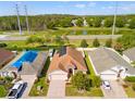 Aerial view of a home with solar panels, a lake view and well-maintained landscaping at 4247 Balmoral Ct, Wesley Chapel, FL 33543
