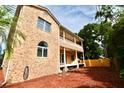 A two-story brick home with a balcony, back yard, and a covered patio at 441 Lucerne Ave, Tampa, FL 33606