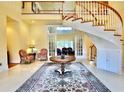 Bright foyer featuring a spiral staircase, a high ceiling, marble floors, and a decorative rug with vintage armchairs at 441 Lucerne Ave, Tampa, FL 33606