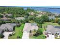 An elevated view of a home featuring a screened pool, landscaping, and access to a scenic lake at 5460 Millbrook Way, Palm Harbor, FL 34685