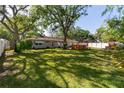 Expansive backyard featuring lush green grass, mature trees, and a wooden deck at 6801 5Th N St, St Petersburg, FL 33702