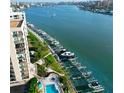 Stunning aerial view of a condo building adjacent to a waterfront with boat docks and lush landscaping at 690 Island Way # 707, Clearwater Beach, FL 33767