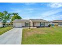 Inviting single-story home with a green lawn, attached garage, and meticulously kept landscaping at 7041 Lexington Cir, Brooksville, FL 34602