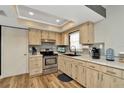 Well-lit kitchen with stainless steel appliances, wood-look cabinetry, and stylish backsplash at 7041 Lexington Cir, Brooksville, FL 34602
