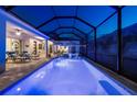 Sparkling swimming pool with spa and screened enclosure and lounge chairs in the backyard at 8580 Ivy Stark Blvd, Wesley Chapel, FL 33545