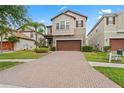 Charming two-story home featuring a brick driveway, attached garage and well-manicured lawn at 935 Terra Vista St, Brandon, FL 33511