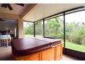Relaxing sunroom featuring a hot tub and scenic outdoor views at 10118 Cleghorn Dr, San Antonio, FL 33576
